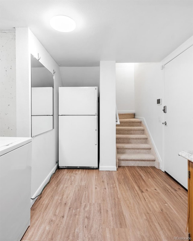 laundry area featuring washer / clothes dryer and light hardwood / wood-style floors