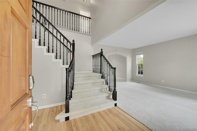 2316 Weatherstone Cir, Highlands Ranch, CO 80126 - entrance foyer with arched walkways, stairs, and wood finished floors