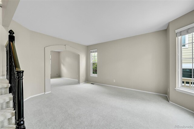2316 Weatherstone Cir, Highlands Ranch, CO 80126 - unfurnished living room featuring light carpet and arched walkways