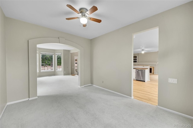 2316 Weatherstone Cir, Highlands Ranch, CO 80126 - empty room with a ceiling fan, arched walkways, and light carpet