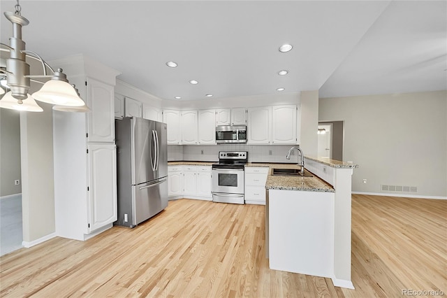 2316 Weatherstone Cir, Highlands Ranch, CO 80126 - kitchen with stainless steel appliances, a peninsula, light wood-style flooring, recessed lighting, and light stone countertops