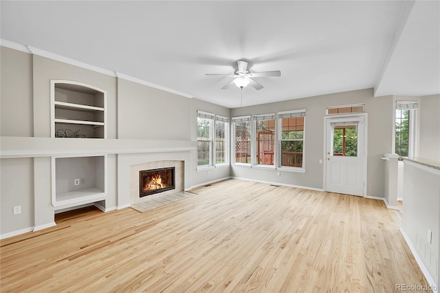 2316 Weatherstone Cir, Highlands Ranch, CO 80126 - unfurnished living room featuring a ceiling fan, wood finished floors, plenty of natural light, and built in shelves
