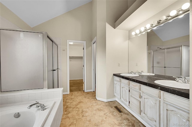 2316 Weatherstone Cir, Highlands Ranch, CO 80126 - full bath featuring a stall shower, double vanity, a bath, vaulted ceiling, and a walk in closet