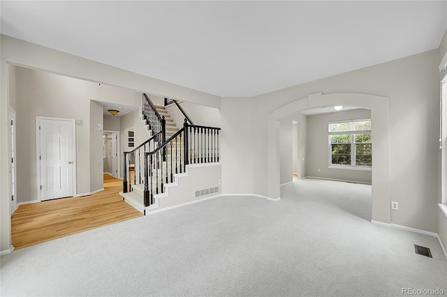 2316 Weatherstone Cir, Highlands Ranch, CO 80126 - carpeted empty room featuring arched walkways and stairway