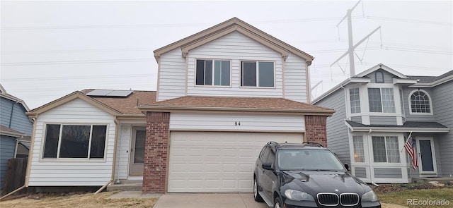 view of front of property featuring a garage and solar panels