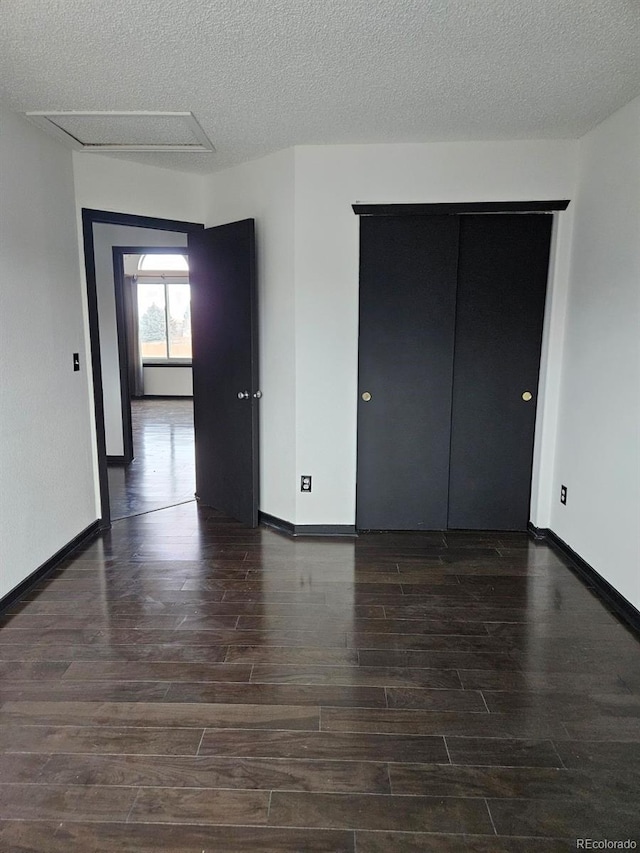 empty room featuring dark hardwood / wood-style floors and a textured ceiling