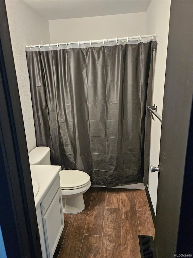 bathroom with toilet, vanity, and a shower with curtain