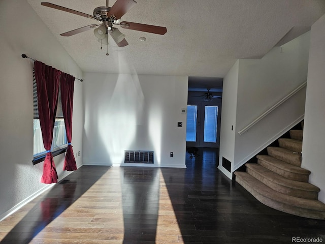 interior space featuring stairs, a textured ceiling, dark wood finished floors, and visible vents