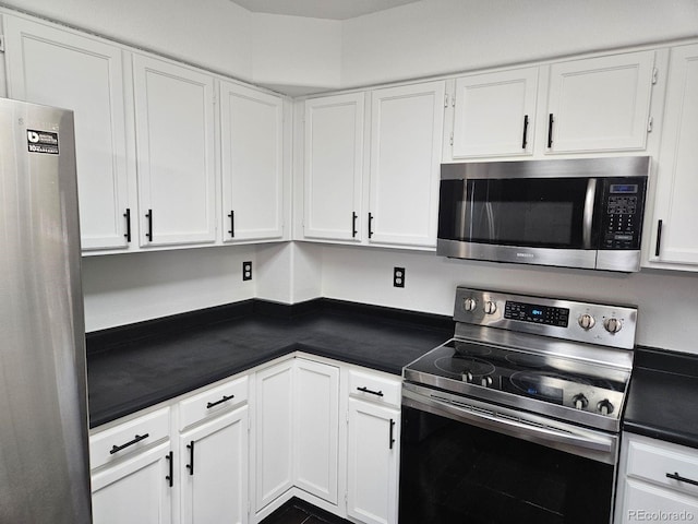 kitchen with dark countertops, white cabinetry, and stainless steel appliances