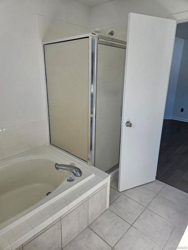 bathroom featuring a stall shower, a garden tub, and tile patterned floors