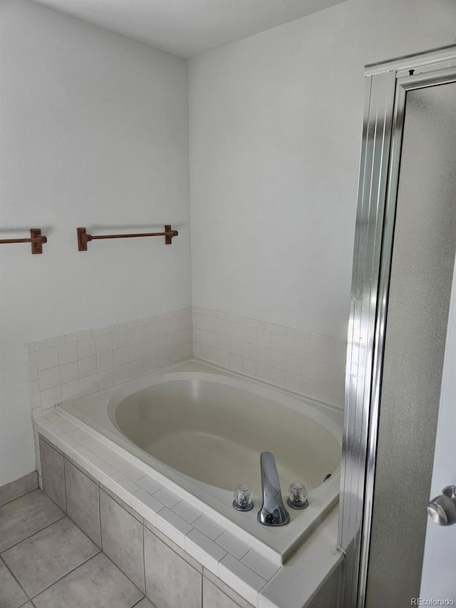 full bath with a garden tub and tile patterned floors