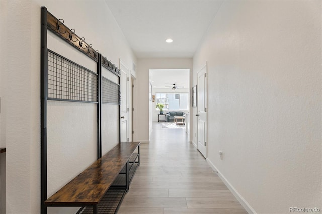 hallway with light wood-style flooring, recessed lighting, and baseboards