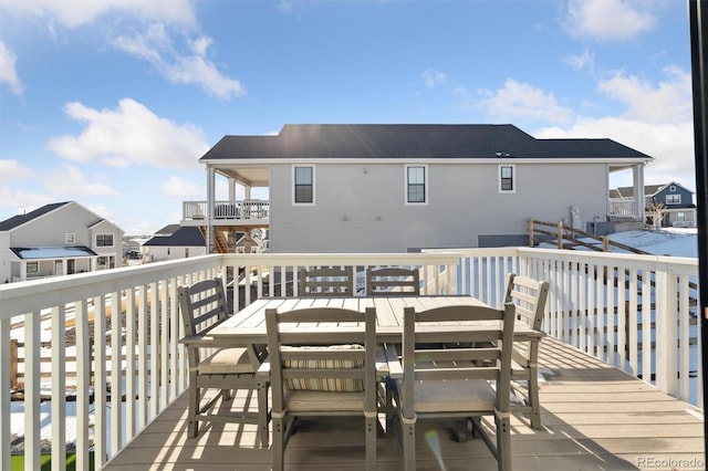 wooden terrace with outdoor dining area and a residential view