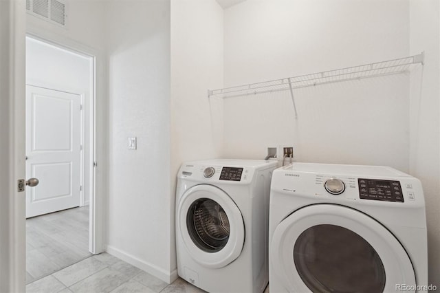 laundry room with laundry area, separate washer and dryer, baseboards, and visible vents