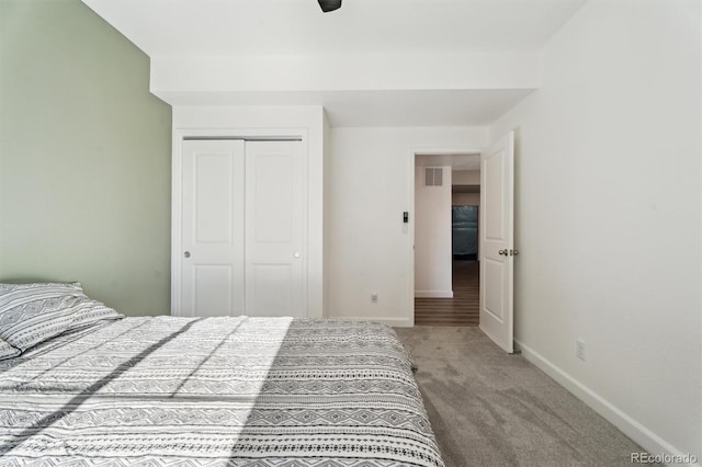 bedroom featuring visible vents, ceiling fan, baseboards, carpet, and a closet