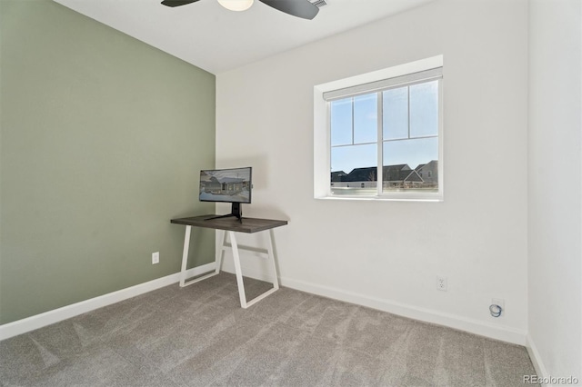 unfurnished office with a ceiling fan, baseboards, and carpet floors