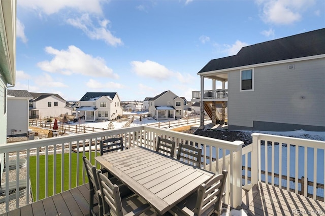 deck with a residential view, a lawn, and outdoor dining space