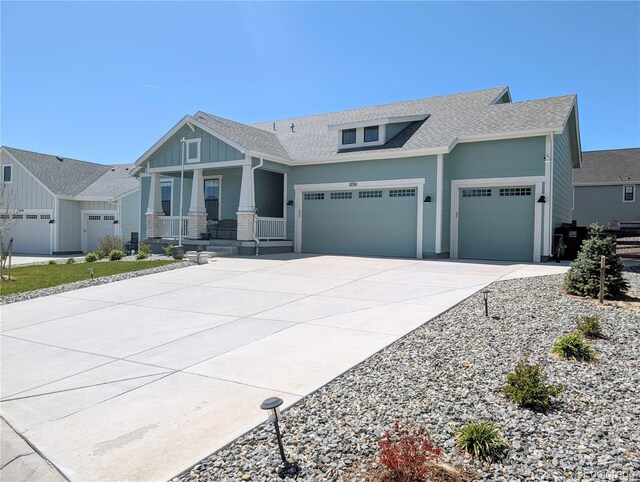 1030 W Hopkins Dr, Elizabeth, CO 80107 - view of front of house featuring covered porch, board and batten siding, roof with shingles, concrete driveway, and an attached garage