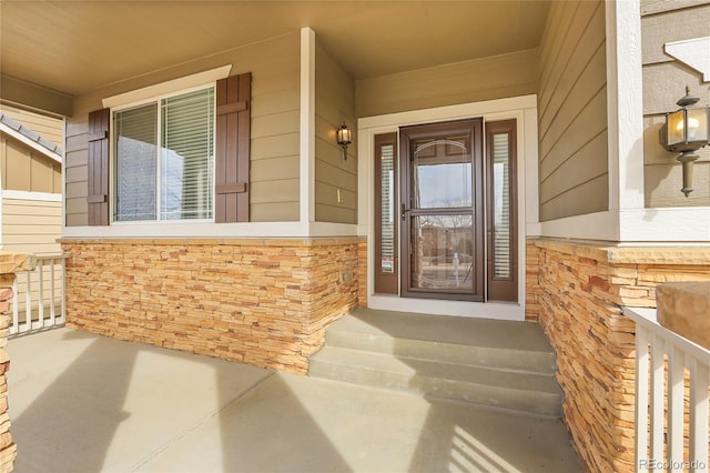 property entrance with stone siding and covered porch