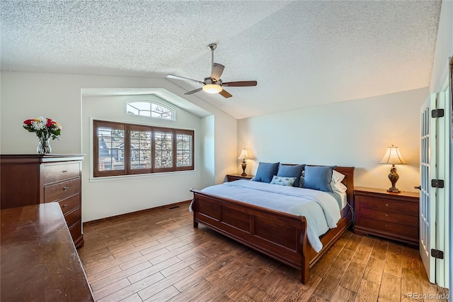 bedroom with vaulted ceiling, ceiling fan, a textured ceiling, and dark hardwood / wood-style flooring