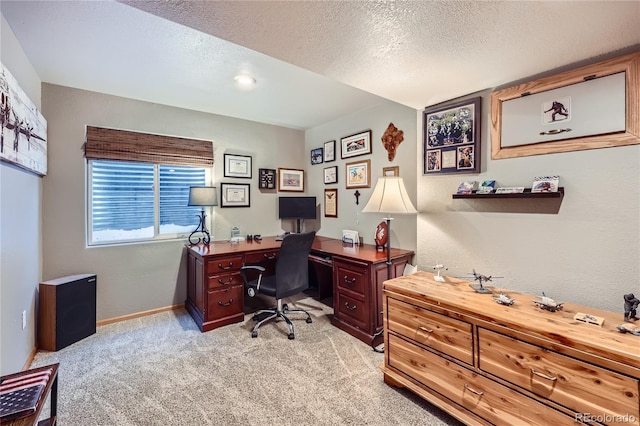 carpeted office space featuring a textured ceiling