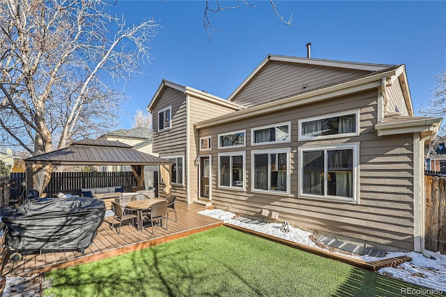 rear view of property with a gazebo, a yard, and a deck