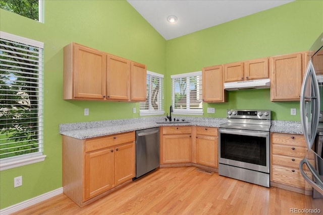 1241 S Akron Way, Denver, CO 80247 - kitchen with appliances with stainless steel finishes, under cabinet range hood, a sink, light brown cabinetry, and high vaulted ceiling