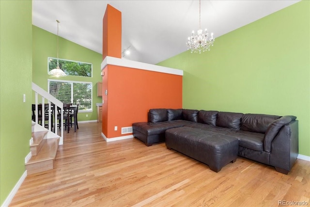 1241 S Akron Way, Denver, CO 80247 - living area with high vaulted ceiling, a chandelier, baseboards, wood finished floors, and stairs