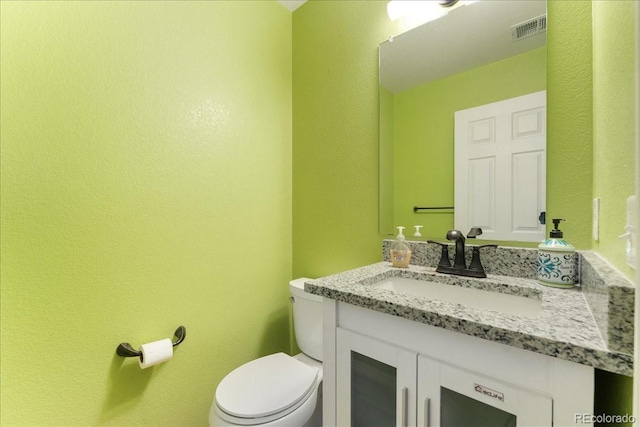1241 S Akron Way, Denver, CO 80247 - half bathroom featuring a textured wall, vanity, and toilet