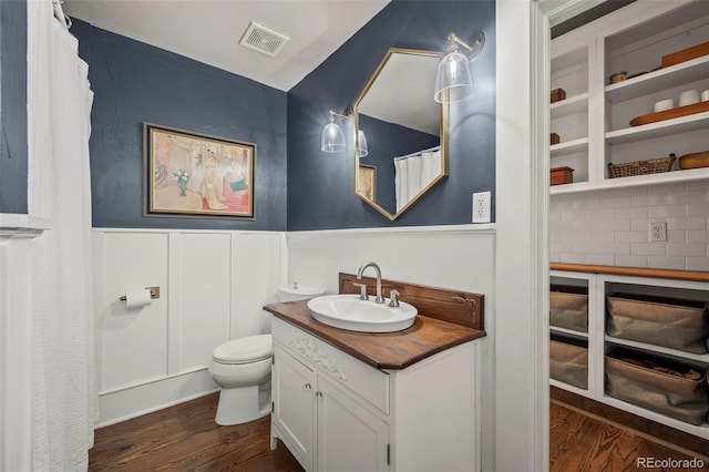 5675 S Crocker St, Littleton, CO 80120 - bathroom with wood finished floors, vanity, a wainscoted wall, toilet, and backsplash