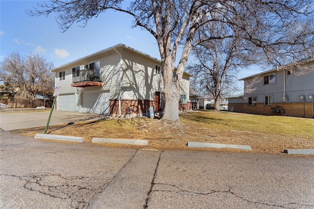 view of front facade with a front lawn, a balcony, a garage, and driveway