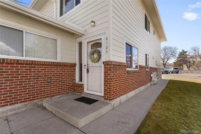 doorway to property featuring brick siding