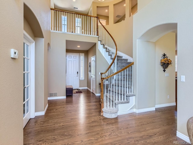 11074 Grayledge Cir, Highlands Ranch, CO 80130 - entrance foyer with wood finished floors, stairs, arched walkways, and a towering ceiling