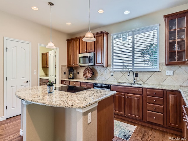 11074 Grayledge Cir, Highlands Ranch, CO 80130 - kitchen featuring appliances with stainless steel finishes, wood finished floors, light stone counters, backsplash, and recessed lighting