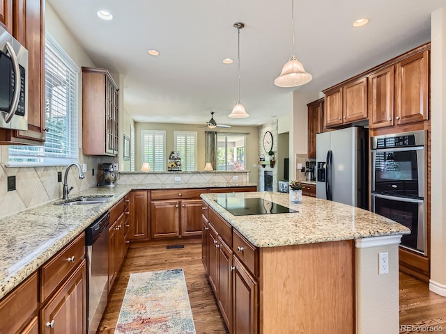 11074 Grayledge Cir, Highlands Ranch, CO 80130 - kitchen featuring appliances with stainless steel finishes, wood finished floors, decorative backsplash, a center island, and recessed lighting