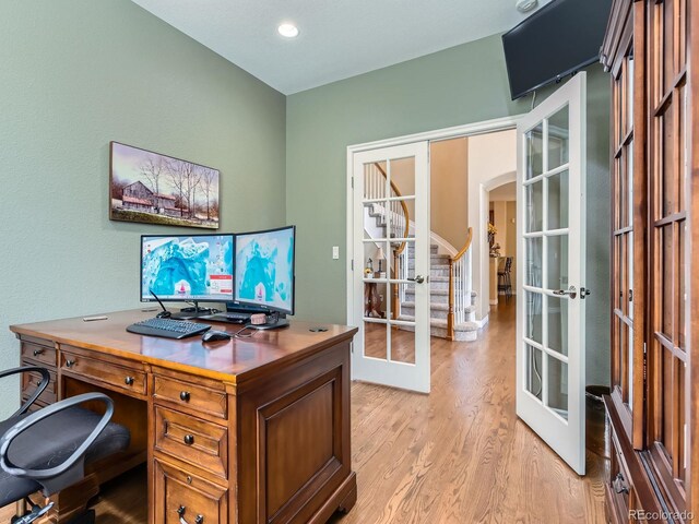 11074 Grayledge Cir, Highlands Ranch, CO 80130 - home office with french doors, arched walkways, and light wood-style flooring