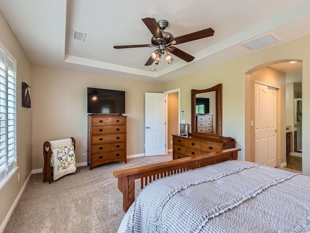 11074 Grayledge Cir, Highlands Ranch, CO 80130 - bedroom with arched walkways, light colored carpet, a raised ceiling, and a ceiling fan