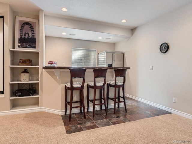 11074 Grayledge Cir, Highlands Ranch, CO 80130 - indoor bar with high end refrigerator, dark colored carpet, dark stone finish flooring, and recessed lighting
