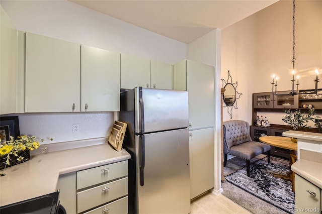 kitchen with stainless steel refrigerator, range, and hanging light fixtures