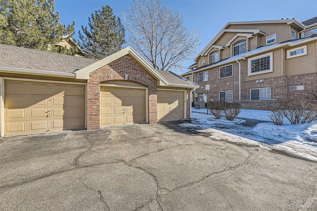 snow covered property featuring a garage