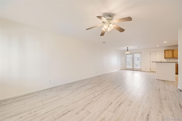 unfurnished living room featuring ceiling fan and light hardwood / wood-style flooring