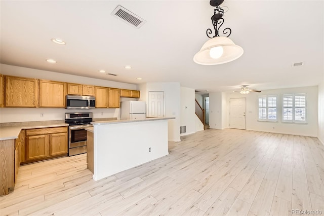 kitchen with a center island, hanging light fixtures, light wood-type flooring, appliances with stainless steel finishes, and ceiling fan