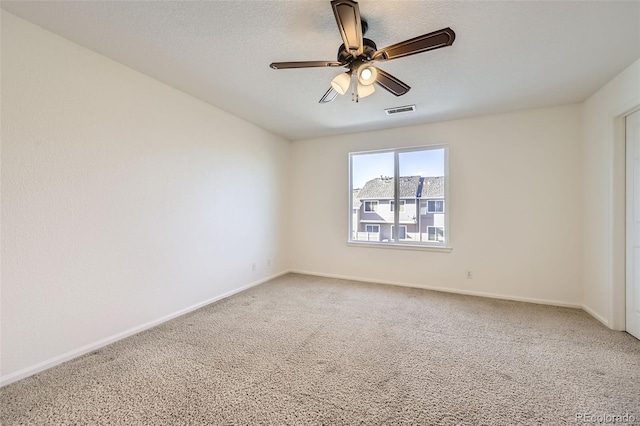 carpeted spare room with a textured ceiling and ceiling fan