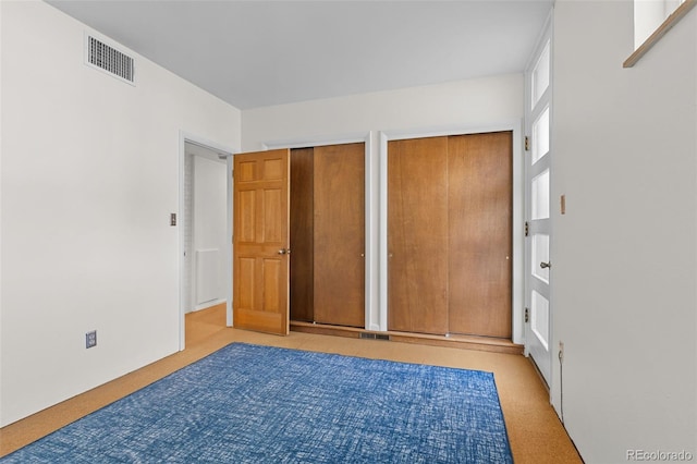 1420 E Bates Ave, Englewood, CO 80113 - unfurnished bedroom with visible vents, carpet, and multiple closets