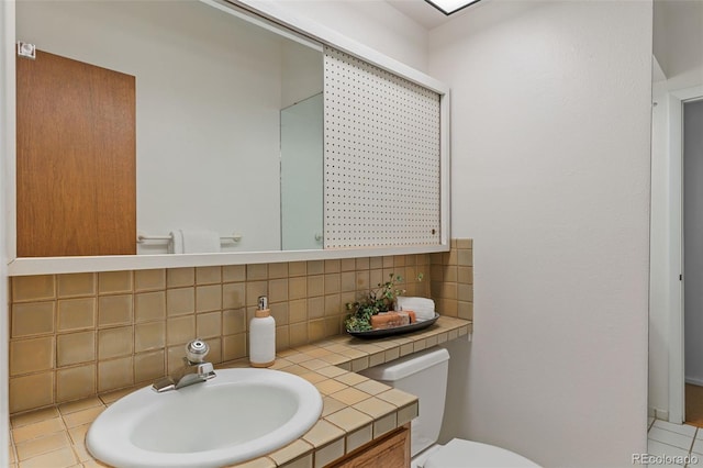1420 E Bates Ave, Englewood, CO 80113 - half bathroom featuring vanity, decorative backsplash, and toilet