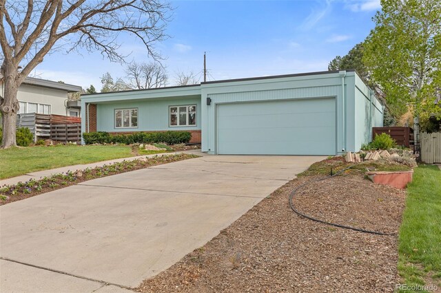 1420 E Bates Ave, Englewood, CO 80113 - view of front facade with driveway, brick siding, fence, a front lawn, and an attached garage