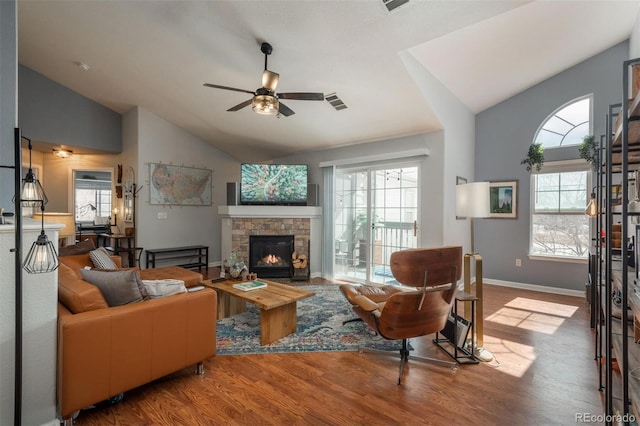 living room featuring lofted ceiling, wood finished floors, and a wealth of natural light