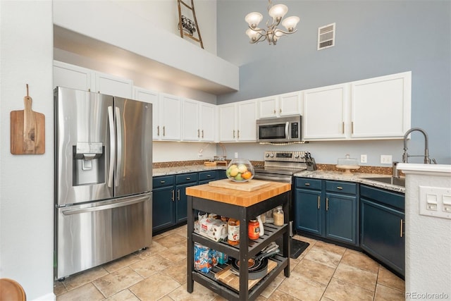 kitchen featuring visible vents, blue cabinetry, light countertops, stainless steel appliances, and white cabinetry