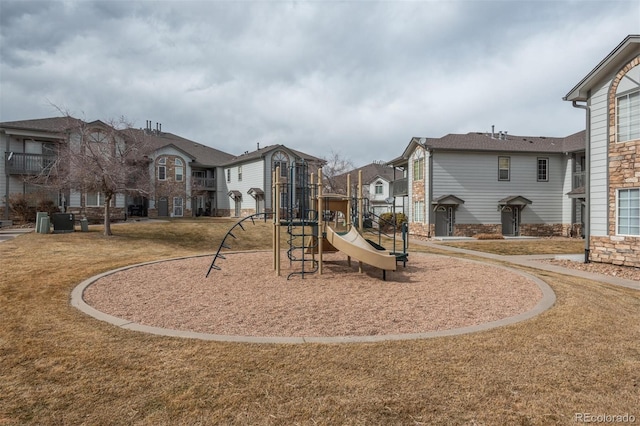 communal playground featuring a yard and a residential view