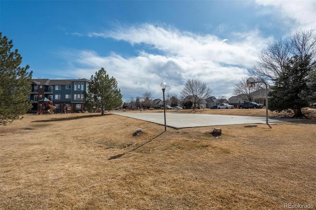 view of yard featuring community basketball court and playground community